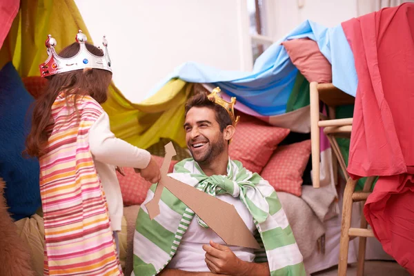 Me estoy divirtiendo mucho. Una linda niña vestida como una princesa mientras juega en casa con su padre. — Foto de Stock