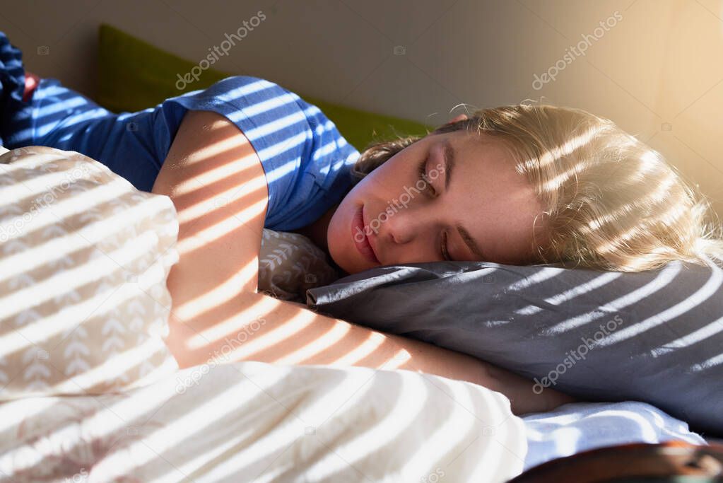 Saturdays are duvet days. Shot of a young woman sleeping peacefully in her bed.