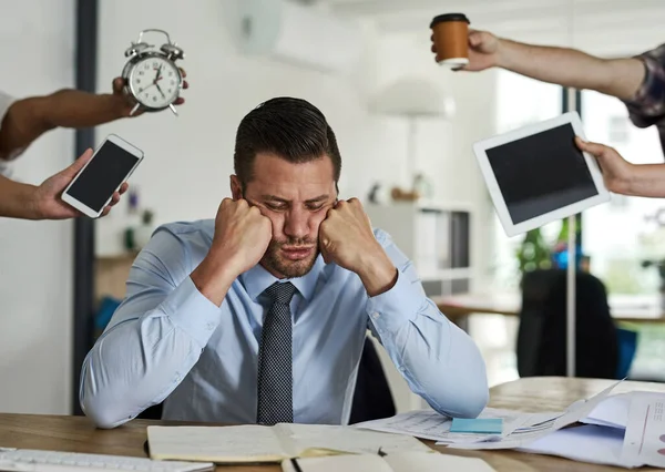 Desejando-lhe os prazos. Tiro de um homem de negócios estressado rodeado de colegas exigentes em um escritório. — Fotografia de Stock