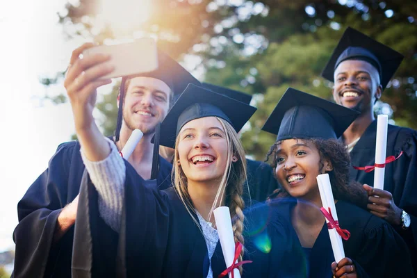 Este es un día que nunca olvidaré. Recorte de un grupo de estudiantes universitarios tomando una selfie en el día de la graduación. —  Fotos de Stock