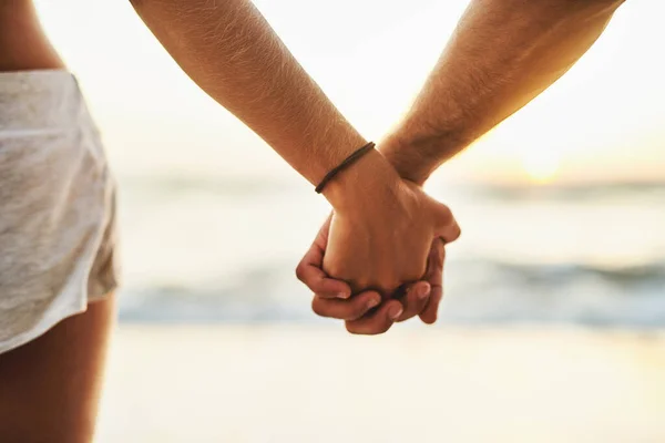 The waves come and go but Ill stay forever. Cropped shot of a young couple holding hands at the beach. — Stock Photo, Image