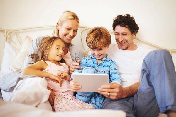 This video is so funny. Cropped shot of a family browsing on a digital tablet together at home. — Stock Photo, Image