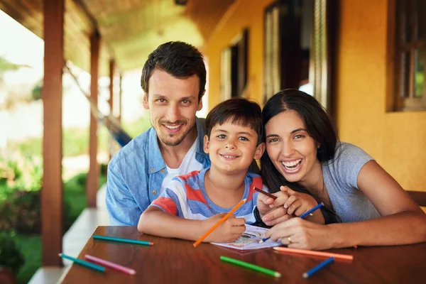 Troviamo il tempo per condividere momenti speciali insieme. Ritratto di una coppia e del loro figlio che colorano insieme all'aperto. — Foto Stock