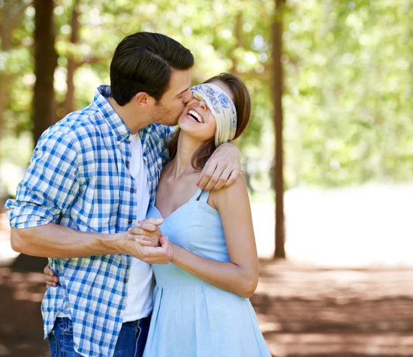 Tengo una sorpresa para ti. Una joven con los ojos vendados riéndose con su novio en el parque. — Foto de Stock