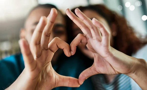 Tú me completas. Foto de una joven pareja haciendo un gesto de corazón con las manos al aire libre. —  Fotos de Stock