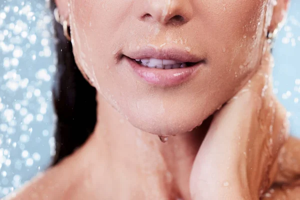 Czuć się świeżo, pachnieć czysto, zawsze ćwiczyć dobrą higienę. Studio ujęcie nierozpoznawalnej kobiety biorącej prysznic na niebieskim tle. — Zdjęcie stockowe