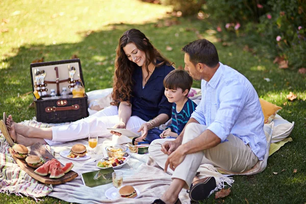 Połączony podczas pikniku. Zdjęcie rodziny cieszącej się wspólnym piknikiem. — Zdjęcie stockowe