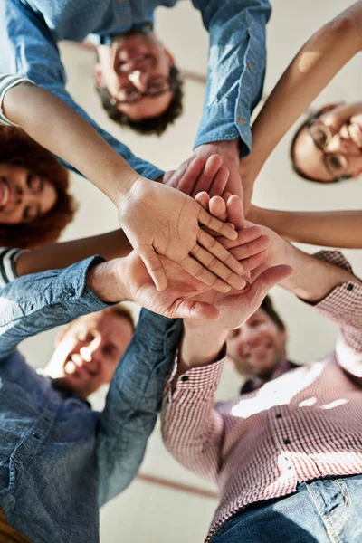 En ella para tener éxito. Retrato de bajo ángulo de un grupo de compañeros de trabajo sonrientes en un grupo. —  Fotos de Stock