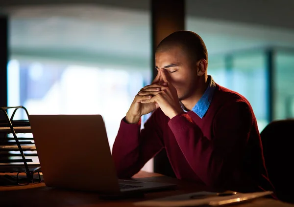 O prazo está a chegar. Tiro de um jovem olhando estressado enquanto trabalhava até tarde em seu escritório. — Fotografia de Stock