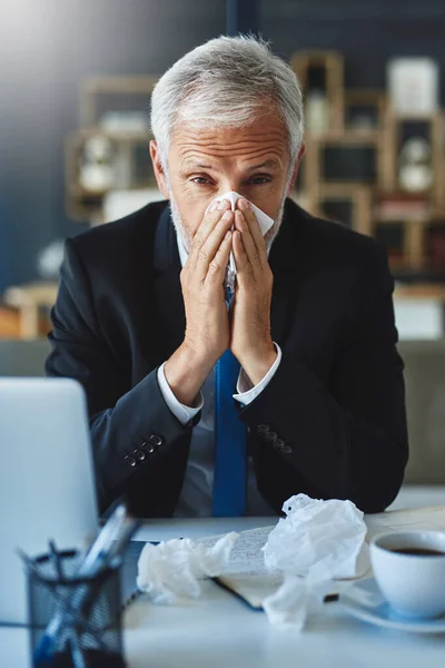 Ik moet het rustig aan doen vandaag. Schot van een gefrustreerde zakenman die een zakdoekje gebruikt om binnen te niezen terwijl hij op kantoor zit.. — Stockfoto