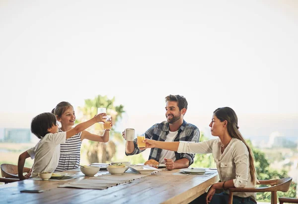 Prendre le petit déjeuner ensemble fait partie intégrante de leur famille. Tourné d'une famille prenant le petit déjeuner ensemble à la maison. — Photo