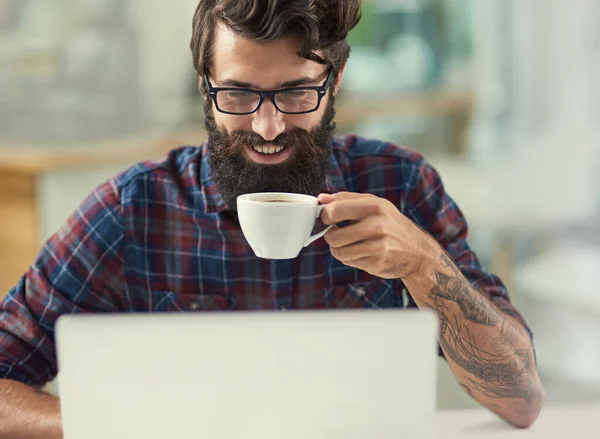 Encontre a inspiração que você precisa para ter sucesso. Tiro de um designer tomando café enquanto trabalhava em seu laptop. — Fotografia de Stock