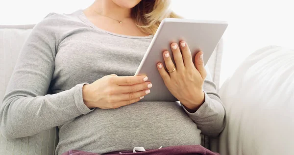 Tohle zařízení je skvělý plánovač těhotenství. Pořízen z nerozpoznatelné těhotné ženy pomocí tablety doma. — Stock fotografie