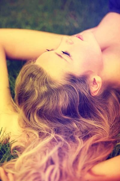 Нагадує сад. Красива молода дівчина лежить на траві зовні . — стокове фото