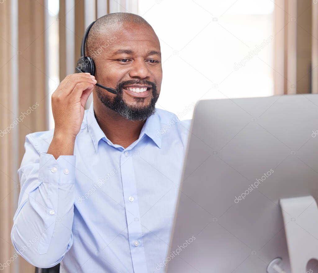 Hes here to help you with anything. Shot of a young male call center agent at work.