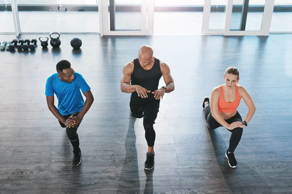 Demostrando la postura correcta. Tiro de personas haciendo ejercicio en el gimnasio. — Foto de Stock