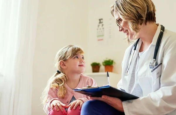 Was würden wir ohne Ärzte tun? Aufnahme eines Arztes bei einer Konsultation mit einem kleinen Mädchen in ihrem Sprechzimmer. — Stockfoto