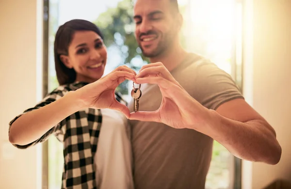 Die Schlüssel liegen bei uns. Porträt eines jungen Paares, das die Schlüssel zu seinem neuen Zuhause in der Hand hält. — Stockfoto