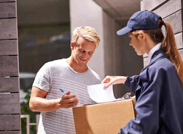 It always arrives on time. Shot of a courier making a delivery to a smiling customer.