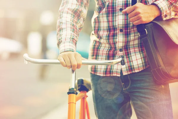 Mantendo a pegada de carbono o mais baixa possível. Tiro cortado de um homem empurrando sua bicicleta na cidade. — Fotografia de Stock