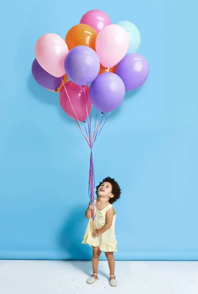 Haruskah kita menari Mr Balon. Ditembak seorang gadis kecil yang lucu memegang sekelompok balon terhadap latar belakang biru. — Stok Foto