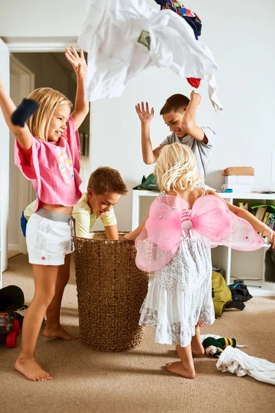 Seine Regenkleidung. Schuss auf kleine Geschwister, die zu Hause Wäsche in die Luft werfen. — Stockfoto