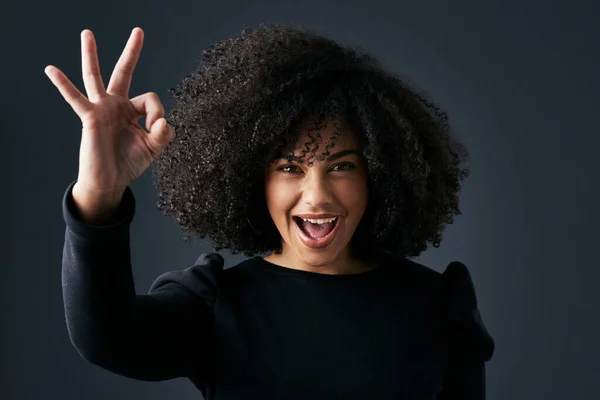 Ser feliz muda o teu mundo. Tiro de uma jovem empresária fazendo gestos de mão contra um fundo de estúdio. — Fotografia de Stock