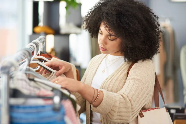 Una chica nunca puede tener demasiada ropa. Foto recortada de una joven comprando ropa en una tienda. — Foto de Stock