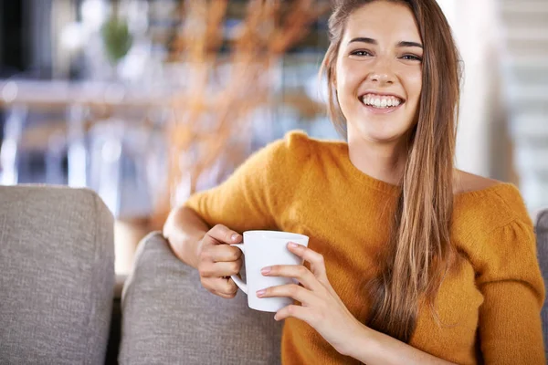 El café me hace feliz. Imagen recortada de una hermosa joven bebiendo café mientras está sentada en el sofá. — Foto de Stock