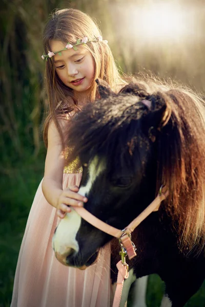 Dont un joli poney. Tourné d'une jolie petite fille jouant avec son poney à l'extérieur. — Photo