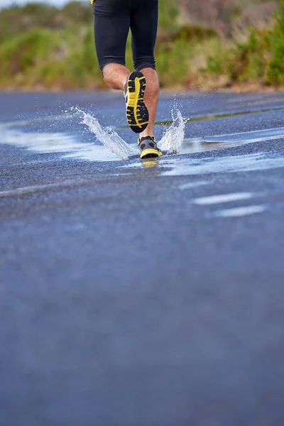 Faça-se à estrada - seja qual for o tempo. Imagem recortada de um corredor pernas como ele corre para a frente. — Fotografia de Stock