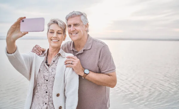 Stavano avendo il miglior pensionamento. Girato di una coppia matura che si fa un selfie mentre è in spiaggia. — Foto Stock