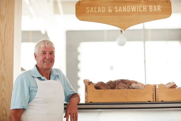Wir machen die besten Sandwiches der Stadt. Porträt eines glücklichen Seniors, der in einer Bäckerei arbeitet. — Stockfoto