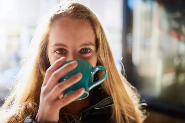 O café aquece o coração e acalma a alma. Retrato de uma jovem atraente desfrutando de um cappuccino em um café. — Fotografia de Stock