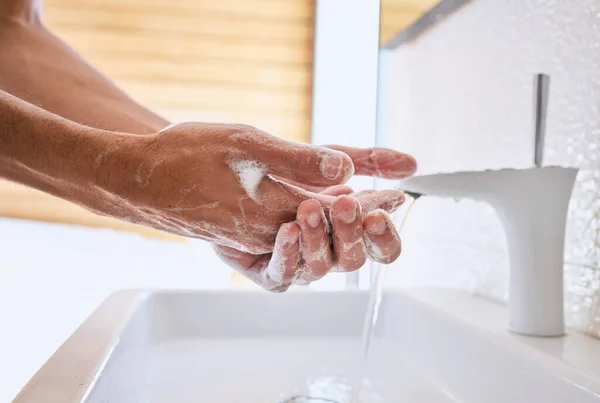Mijn handen fris en schoon houden. Schot van een onherkenbare man die thuis zijn handen wast in een badkamer. — Stockfoto