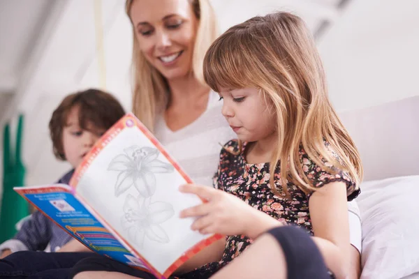 Παίρνοντας μια περιπέτεια ανάγνωσης μαζί. Φωτογραφία μητέρας που διαβάζει με τα παιδιά της στο σπίτι. — Φωτογραφία Αρχείου