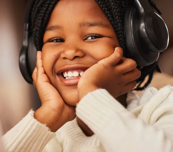 Muzyka jest lekarstwem na wszystkie złe dni. Strzał małej dziewczynki noszącej słuchawki w domu. — Zdjęcie stockowe