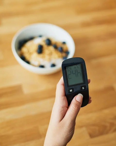 Everything looks good. Closeup shot of an unrecognizable woman testing her blood sugar level with a glucose meter before breakfast. — Stock Photo, Image