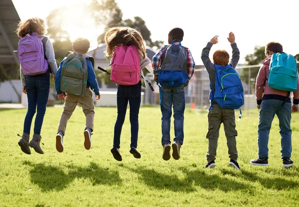 Jump for joy, its holiday. Shot of young kids playing together outdoors. — Stock Photo, Image