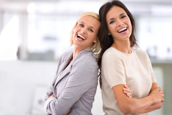 C'est à propos des gens avec qui tu travailles. Portrait de deux collègues féminines debout ensemble dans le bureau. — Photo