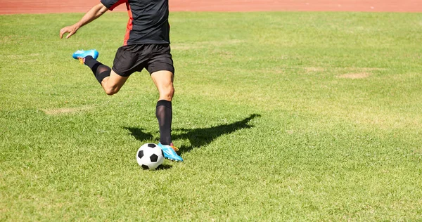 Má dokonalou techniku výstřelu. Postřelen mladý fotbalista hrající si s míčem venku. — Stock fotografie