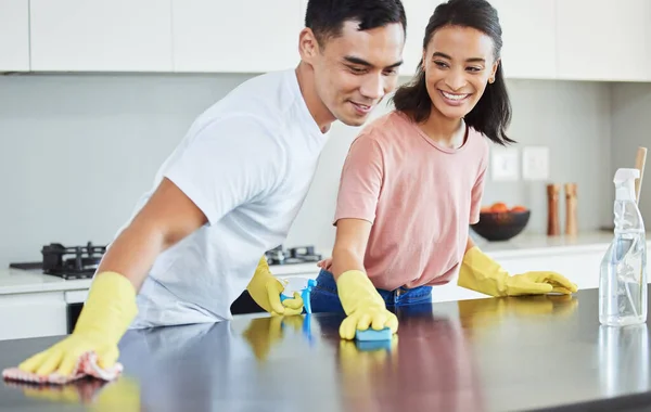 You make even the mundane exciting. Shot of a young couple cleaning their kitchen together. — ストック写真