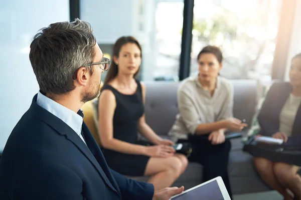 Когда он говорит, все слушают. Снимок группы бизнесменов, слушающих своего менеджера во время встречи. — стоковое фото