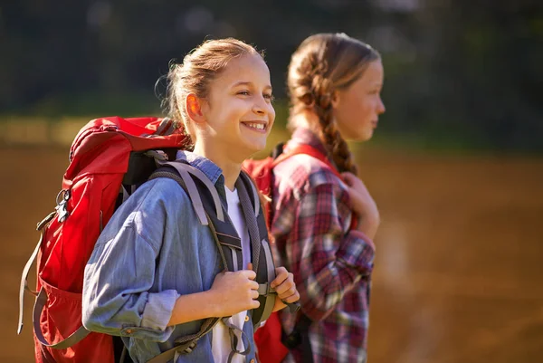 Sem preocupações na natureza. Tiro de duas meninas usando mochilas andando juntas. — Fotografia de Stock