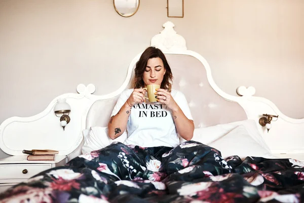 나는 먼저 커피를 마시지 않는 날을 직면한다. 아름다운 젊은 여자가 침대에서 커피를 마시고 있는 장면. — 스톡 사진