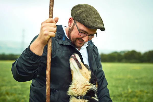 Mon meilleur ami et moi. Tourné d'un jeune fermier joyeux et son chien se regardant tout en se tenant sur un champ vert sur la ferme. — Photo
