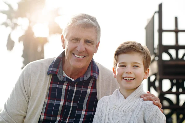 Es seguro decir que he transmitido los buenos genes. Retrato de un adorable niño posando con su abuelo mientras se relaja al aire libre. —  Fotos de Stock