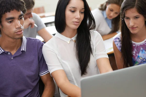 Mostrándoles cómo se hace la investigación. Fotografía de un grupo de estudiantes universitarios que trabajan en ordenadores portátiles en clase. — Foto de Stock