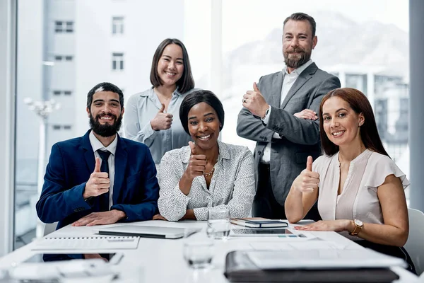 Duch zespołu promuje większe osiągnięcie. Portret grupy biznesmenów pokazujących razem kciuki w biurze. — Zdjęcie stockowe