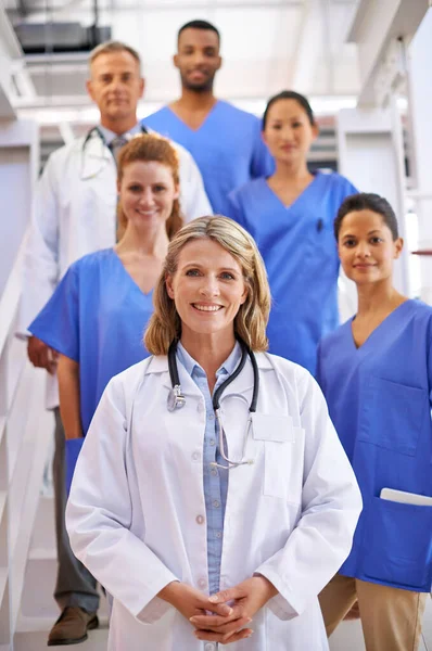 Přišli jsme se o tebe postarat. Portrét rozmanitého týmu lékařů stojících na schodišti v nemocnici. — Stock fotografie